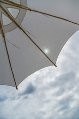 a white beach umbrella covering half the sky