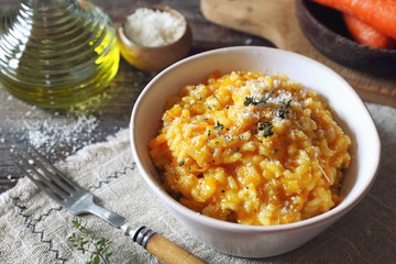 Italian cuisine. Bowl of carrot risotto, olive oil and grated parmesan cheese