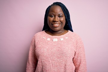 African american plus size woman with braids wearing casual sweater over pink background with a happy and cool smile on face. Lucky person.