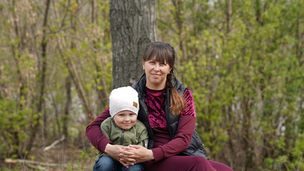 Beautiful Mom with cute little son in park in spring