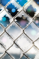 Art BACKGROUND with a FLOATING focus of a snow-covered steel mesh in multi-colored highlights