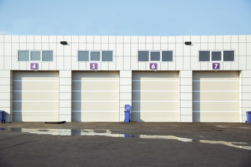 Fototapeta na wymiar Shutter door or roller door and concrete floor outside .White Automatic shutters in a house . gates in the garage . Automatic Electric Roll-up Gate Or Push-up Door In The Modern Ground Floor .