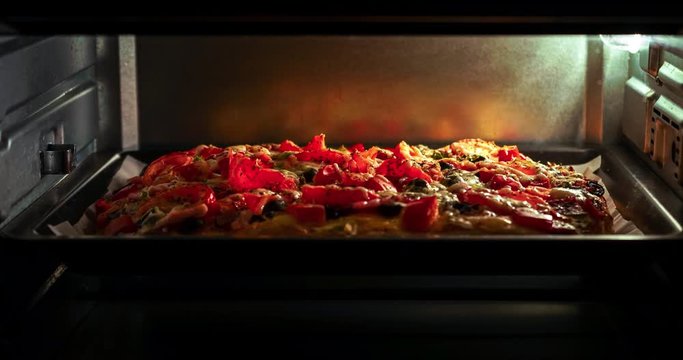 Preparation of home made pizza with a chicken, bacon, olives, cheese, at oven microwave time-lapse