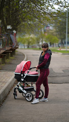 Young mother with a pram in the park