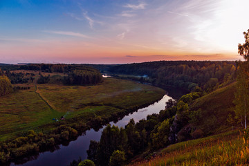 Fototapeta na wymiar river and forest from a high hill at sunset