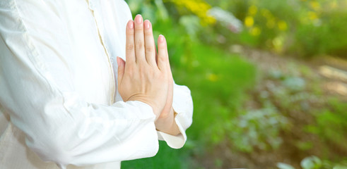 Close up of woman hands in namaste gesture. Female meditation outdoors. Prayer position.