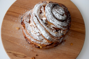 Kraffin Easter cake in powdered sugar with raisins, dried apricots and nuts on wooden cutting board