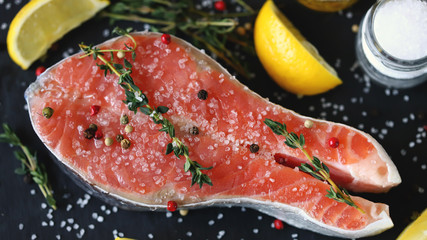 Salted salmon slice with sea salt and spices on a stone board. Keto Paleo. Pegan diet.