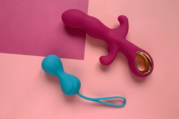 Sex toys. Pink vibrator ang blue  jiggle balls on a pink background. Sex gadget and masturbation...
