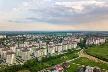 Top view of urban developing city landscape with tall apartment buildings and suburb houses. Drone aerial photography.