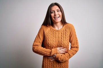 Young beautiful woman with blue eyes wearing casual sweater standing over white background smiling...