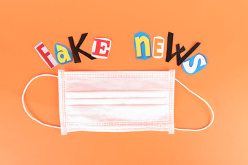 L'insciption Fake news, collage of colored paper's letters, with medical face mask. The concept of...
