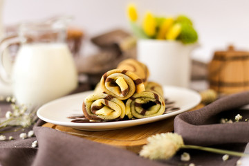 Sweet thin pancakes on a white plate.  Striped pancakes spun by rolls.  Photo of the finished dish...