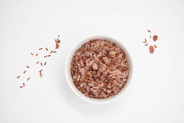 Top view of a bowl of red rice with peanuts