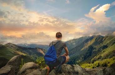 Sporty hiking girl enjoying beautiful mountain view. Back photo of female hiker resting.