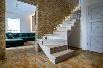 Stylish wooden contemporary staircase inside loft house interior. Modern hallway with decorative...