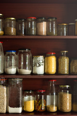 Shelved stacked with raw ingredients in glass jars. 