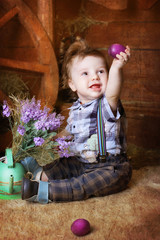 little boy with Easter eggs and live rabbits