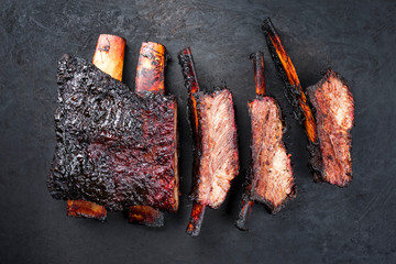 Barbecue burnt chuck beef ribs marinated and sliced with hot chili sauce as top view on an old...