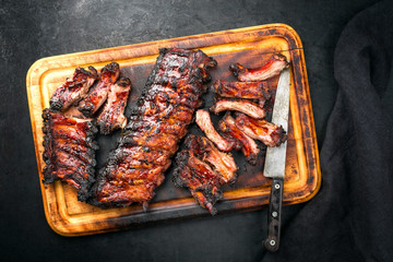 Barbecue pork spare loin ribs St Louis cut with hot honey chili marinade burnt as top view on a wooden cutting board