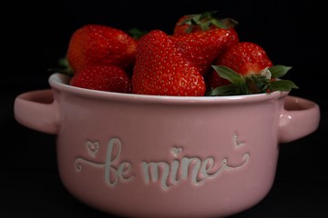 Fresh red strawberries in a bowl. Strawberry fruits on a black background. Copy space for text....