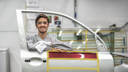 Portrait of an employee of the car body painting shop in protective clothing