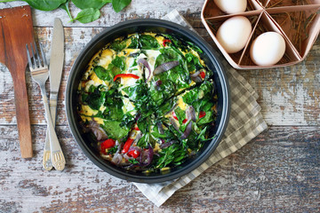 Selective focus. Healthy homemade omelet with spinach and vegetables. Spinach omelet in a pan. Cooking healthy food at home.