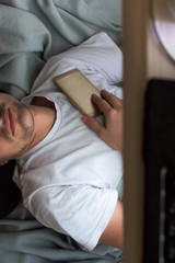 Man addicted to cell phones falls asleep with the phone on his chest. Man Hipster sleeping in quarantine, due to coronavirus. Stay at home. workaholic fell asleep. Covid-19.