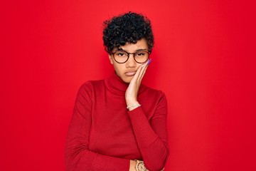 Fototapeta na wymiar Young beautiful african american afro woman wearing turtleneck sweater and glasses thinking looking tired and bored with depression problems with crossed arms.