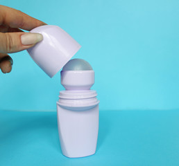 White bottle with Body antiperspirant deodorant roll-on on blue background.