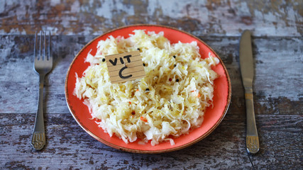 Selective focus. Note with the inscription Vit C in a plate with sauerkraut. Healthy homemade food. Fermented foods. Probiotics