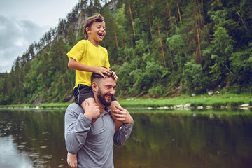 Having fun. Father example of noble human. Child riding on dads shoulders. Happiness being father...