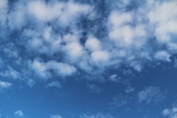 White clouds and blue sky as background. Photo of sky in sunny day. Nature background.