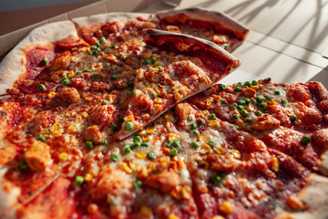 Hot tasty pizza ready to eat. Pizza in a cardboard box against a sunny background. Pizza delivery. Pizza menu.