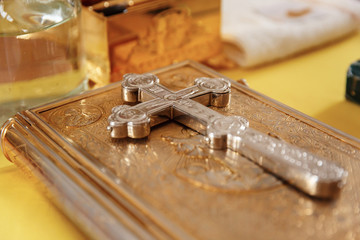 Golden gospel (holy bible) book and a silver cross on it. Russian eastern orthodox church.