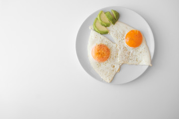 Scrambled eggs with avocado and specialy on a white plate on a white background with blank copy space, top view