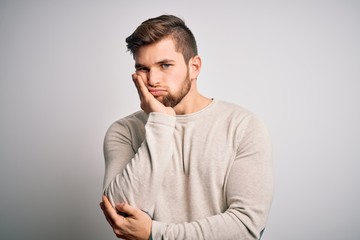 Young handsome blond man with beard and blue eyes wearing casual sweater thinking looking tired and bored with depression problems with crossed arms.