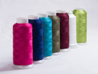 yarn rolls in various colors against a white background