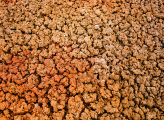 Texture of dry cracked rusty soil, eroded land affected by periods of heavy rain and drought.