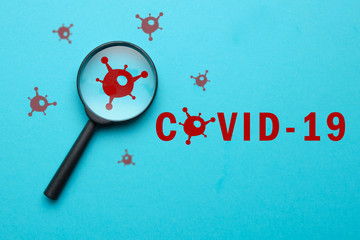 Coronovirus covid-19 answers and questions concept - magnifier with virus sign on blue background.