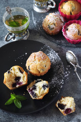 Blueberry muffins and tea on dark background - 341124246