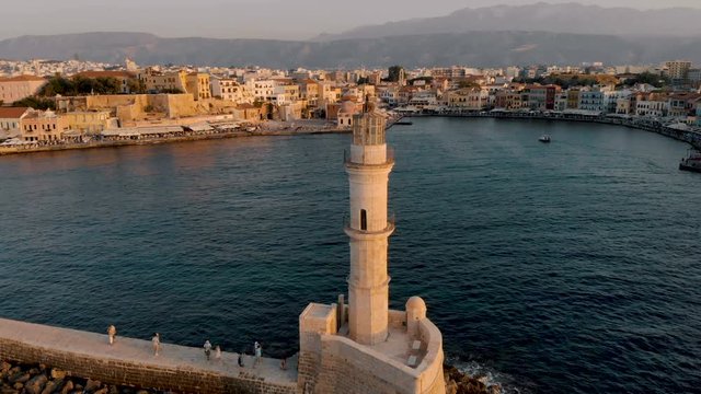 Aerial drone panoramic view video of amazing  Chania old harbor during the golden hour. Orbiting around  of lighthouse and old Venetian harbor of  Crete, Greece