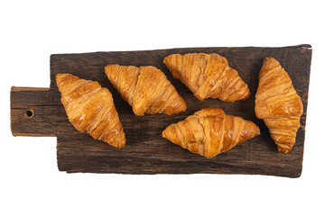 Fresh flavorous croissant on wooden table isolated on white