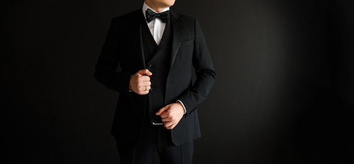 Obraz na płótnie Canvas Close up of man who is arranging his black suit
