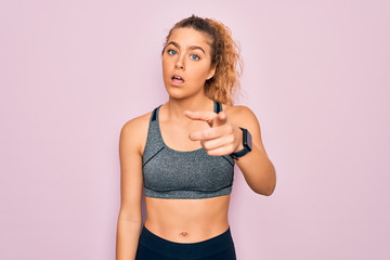 Young beautiful blonde sportswoman with blue eyes doing exercise wearing sportswear pointing displeased and frustrated to the camera, angry and furious with you