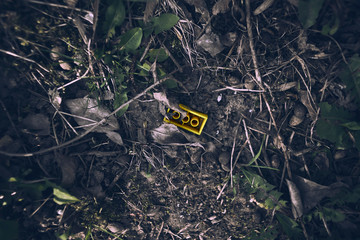 Lost toy block laying forgotten in a dust on a ground.