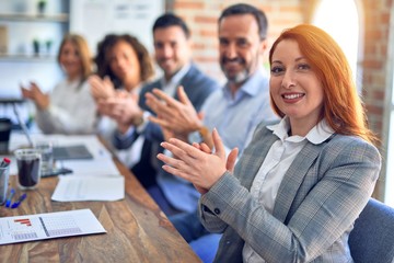 Group of business workers smiling happy and confident. Working together with smile on face looking at the camera applauding at the office