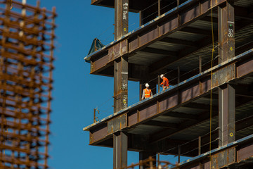 Close up of commercial office building under construction with construction workers,rebar,steel...
