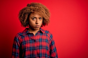 Fototapeta na wymiar Young beautiful African American afro woman with curly hair wearing casual shirt skeptic and nervous, frowning upset because of problem. Negative person.