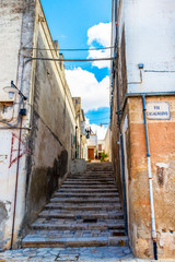 Fototapeta na wymiar Narrow stairway street in the old town of Matera, Province of Matera, Basilicata Region, Italy. Translation - Casalnuovo Street